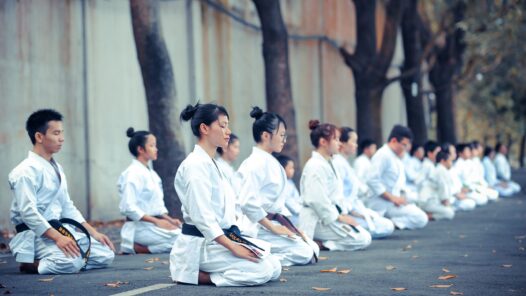 group of martial artists sitting on the grounds